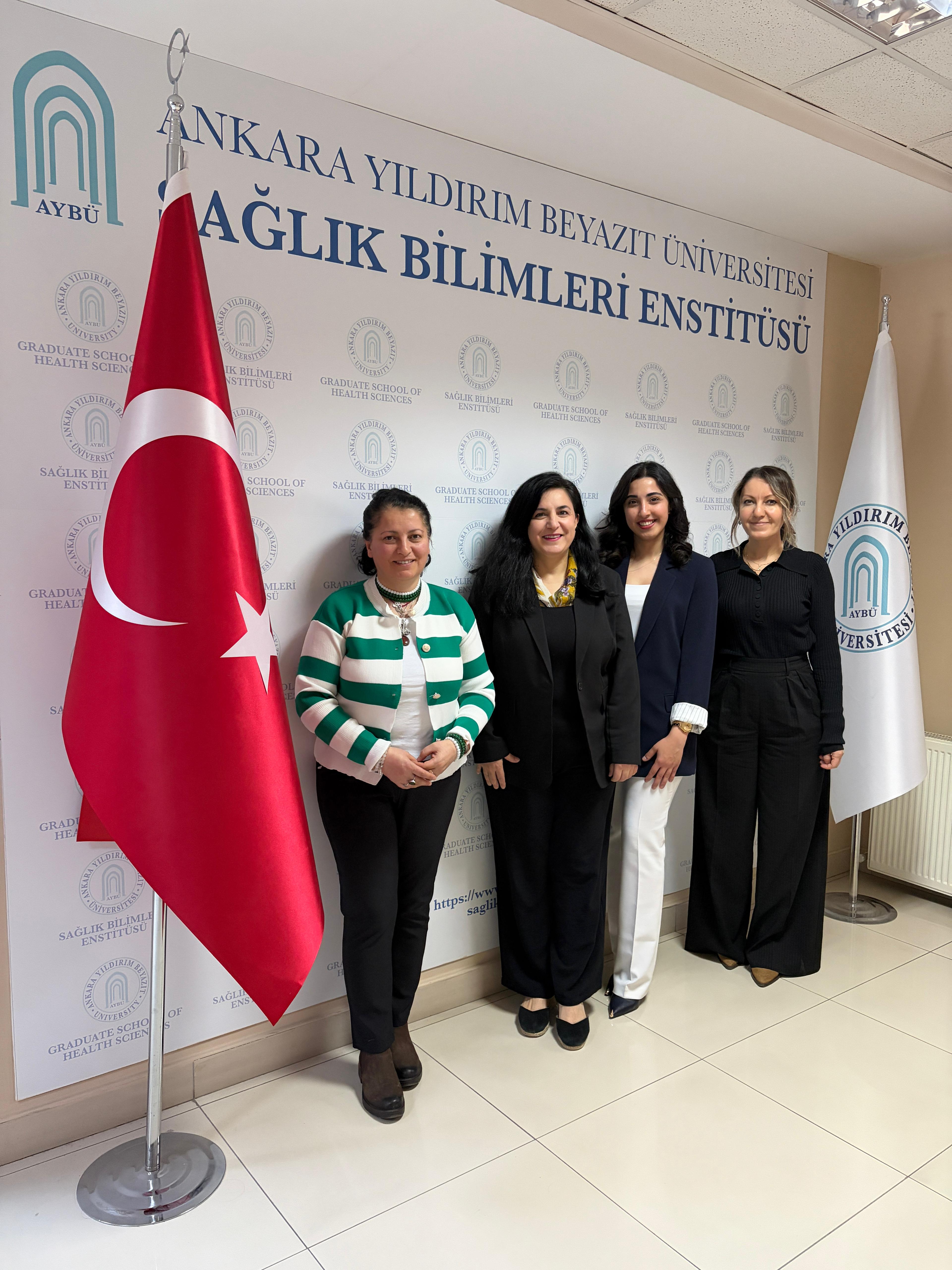 Görselde, tez savunmasını tamamlayan öğrenci ve danışmanı ile jüri üyelerinin birlikte yer aldığı bir fotoğraf bulunmaktadır.