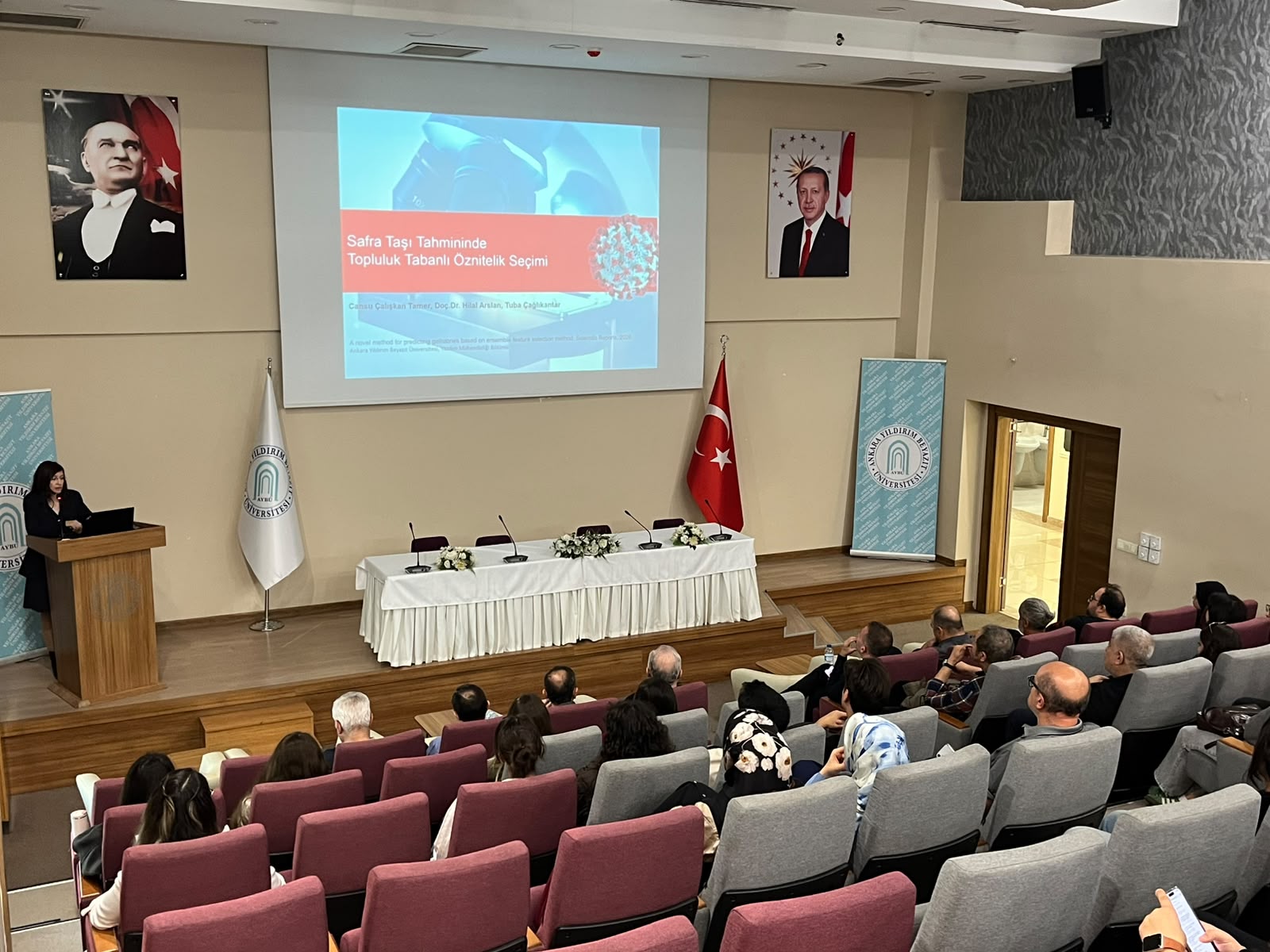 Doç. Dr. Hilal Arslan konuşmasını yaparken dinleyicilerile birlikte salonun arkadan fotoğrafı.