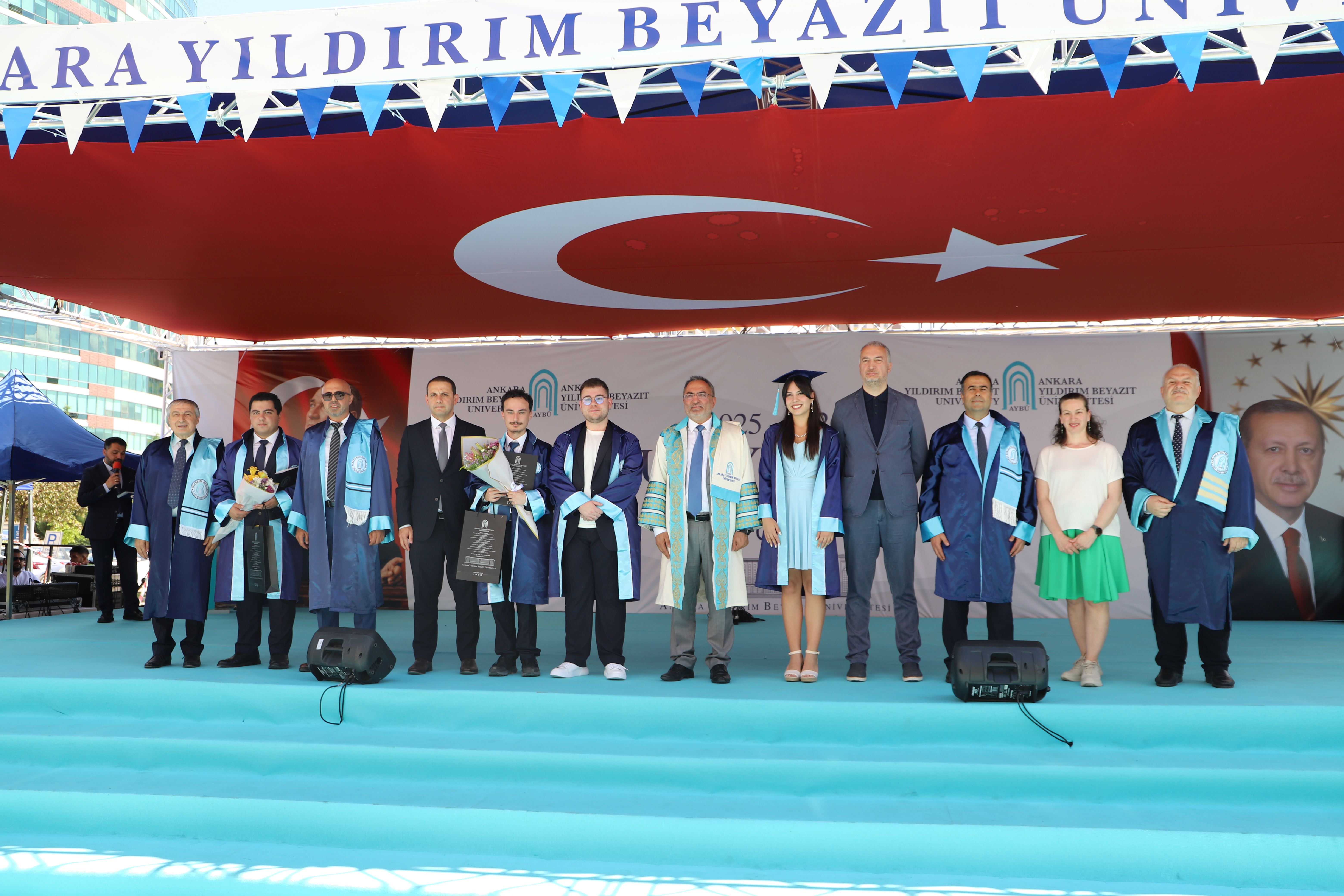 Rektörümüz, rektör yardımcımız, değerli misafirlerimiz ve fakülteden dereceyle mezun olan öğrencilerimizin sahnede toplu fotoğrafı.