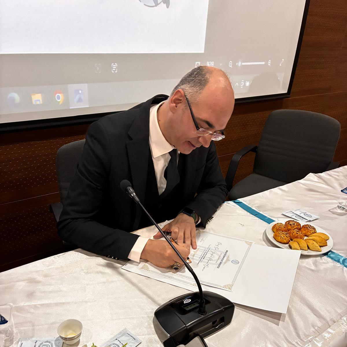 Our professor is signing a document.