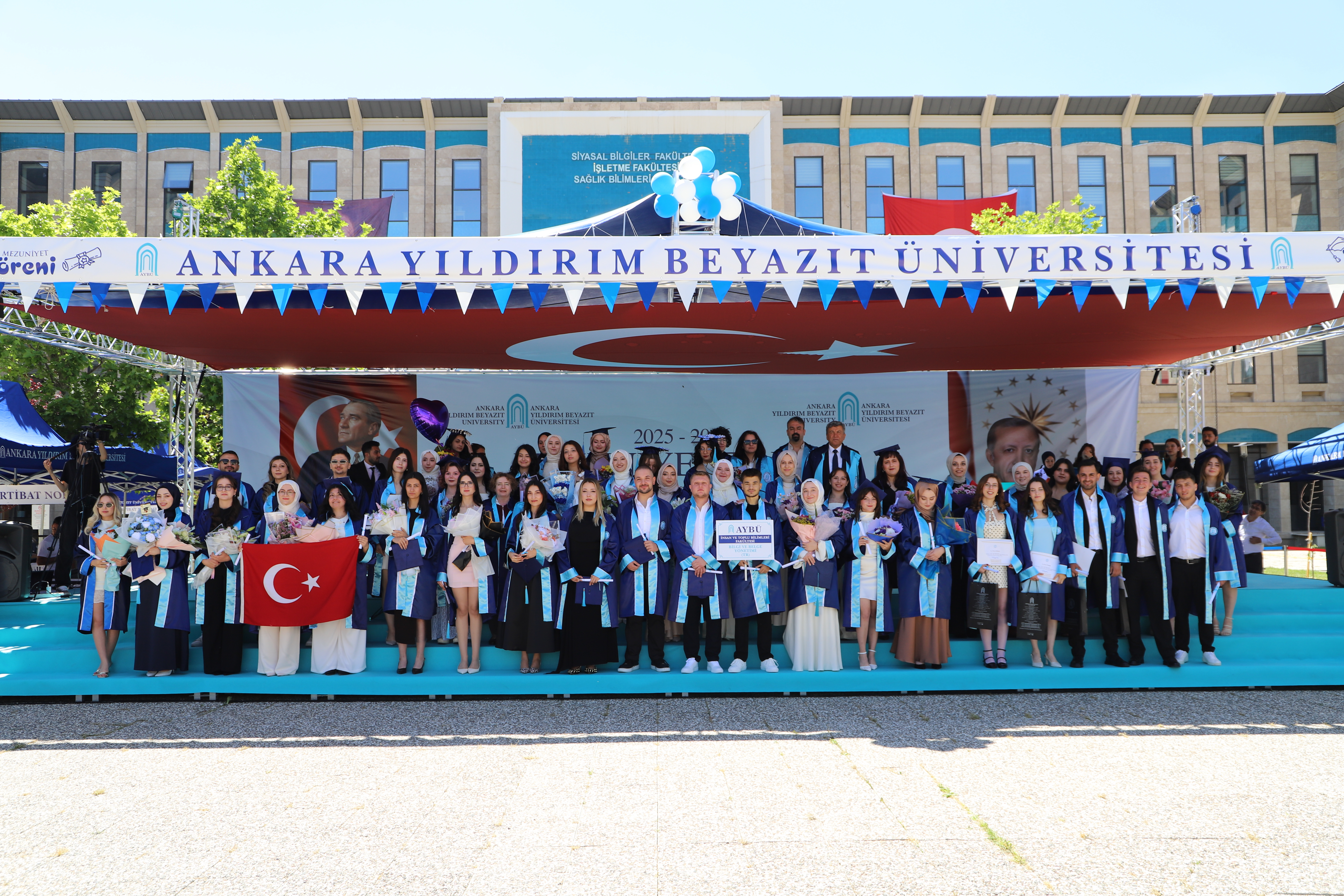 Mezun olan öğrencilerin ve hocaların sahnede çekilmiş bir fotoğrafı