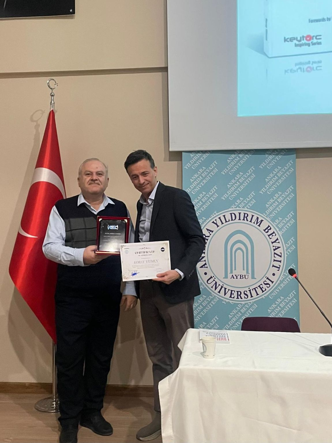 Dekanımız Koray Yitmen'e plaket ve sertifika veriyor.