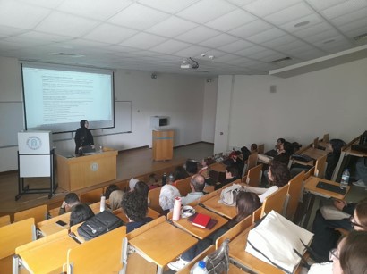 Oryantasyon programında amfide konuşma yapan kişi ve dinleyiciler. A speaker addresses attendees in a lecture hall at the orientation program.