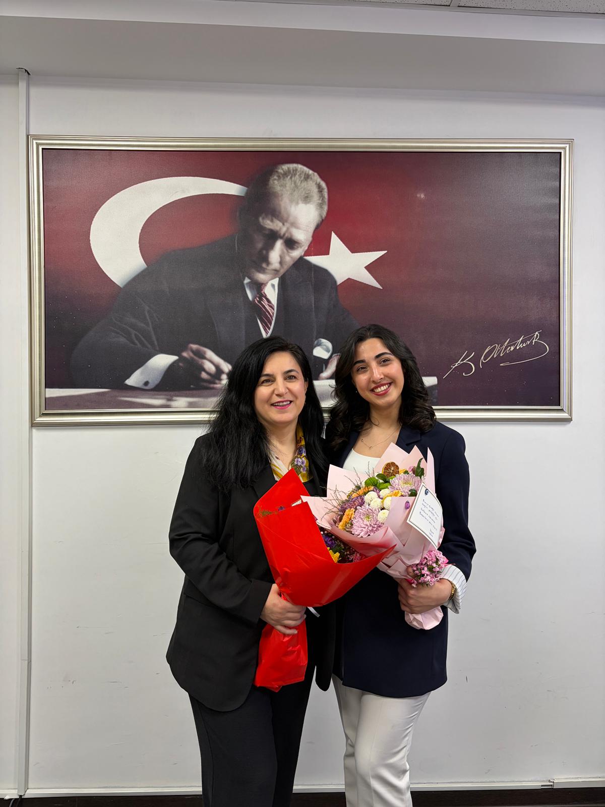 Görselde, tez savunmasını tamamlayan öğrenci ve danışmanı ile jüri üyelerinin birlikte yer aldığı bir fotoğraf bulunmaktadır.