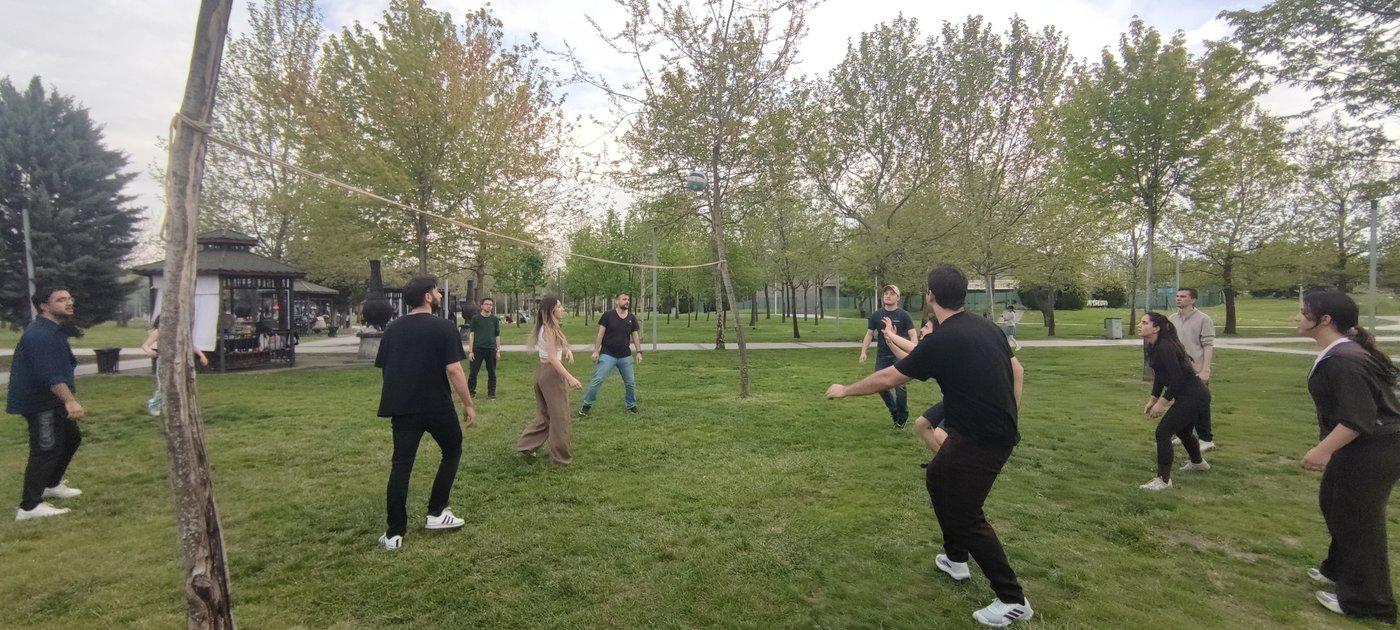 Students play a volleyball match in the open area, combining teamwork and entertainment.