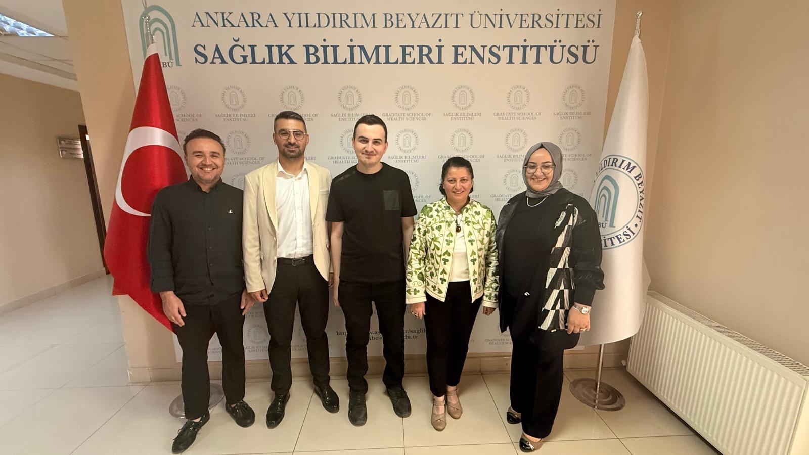 Görselde, tez savunmalarını başarıyla tamamlayan Ody. Hüseyin Bilgici ve Ody. İsmail Cem Gülmez ile danışmanları ve jüri üyeleri birlikte yer almaktadır.