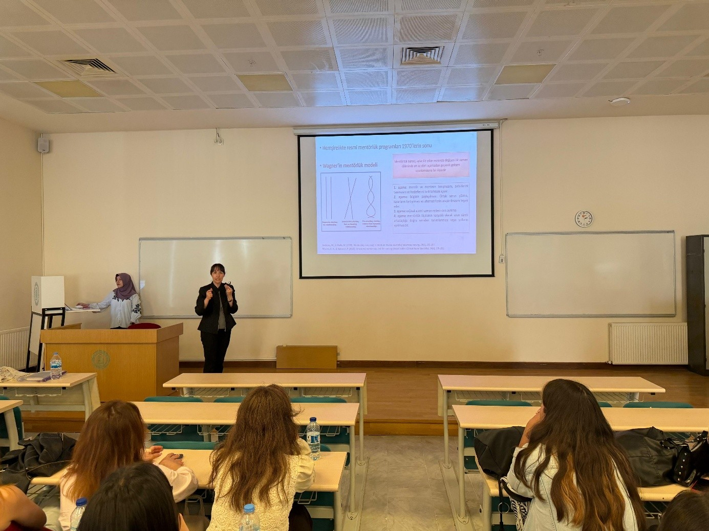 Associate Professor Reyhan Eskiyurt and Research Assistant Şeyma Zübeyde ALBAKIR explaining the stages of the Mentor–Mentee Program to first-year students.