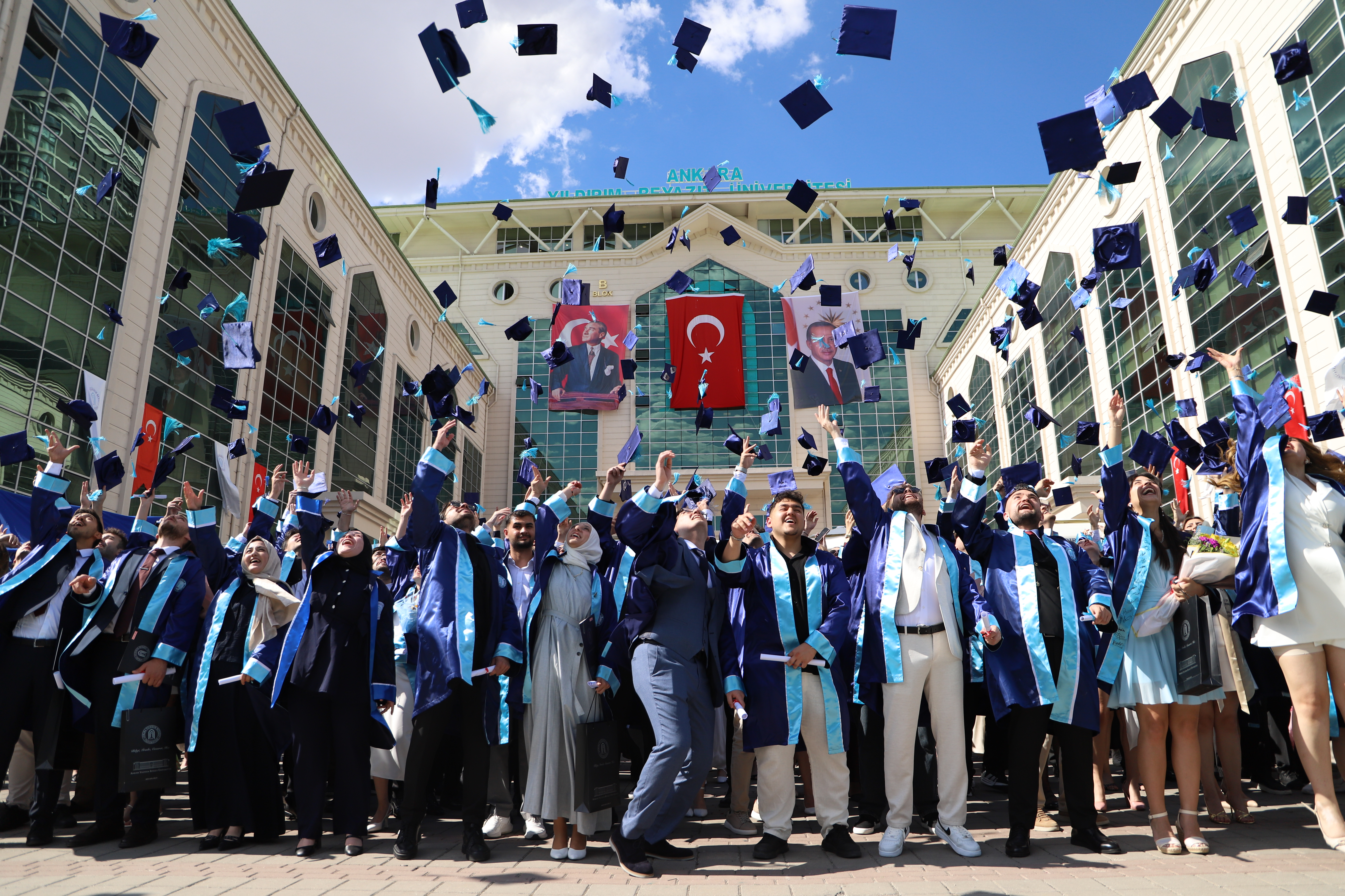 Graduating students celebrate by tossing their graduation caps into the air.